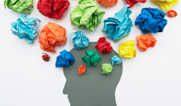 colorful paper balled up above the outline of a persons head