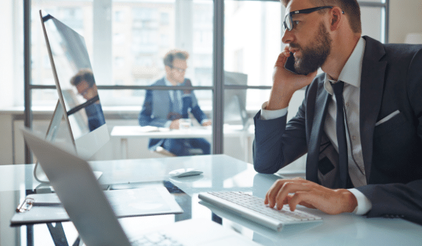 two people at desks in an office